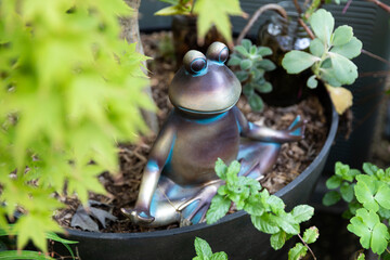 Garden frog statue seated in meditation yoga pose 