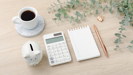 Obraz na płótnie Canvas Calculator with piggy bank and notebook on light wood desk
