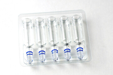 ampoules with medicine in a transparent tray on a white background