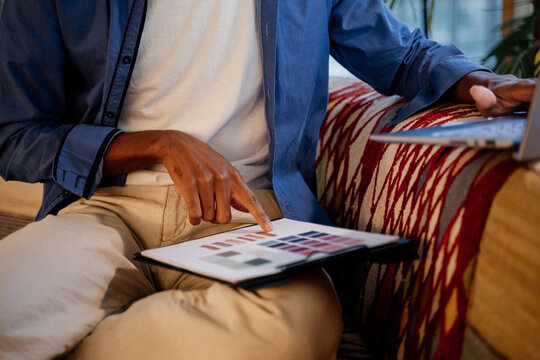 Close-up of man with color palette paper on clipboard