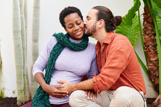 Man kissing his pregnant wife outside