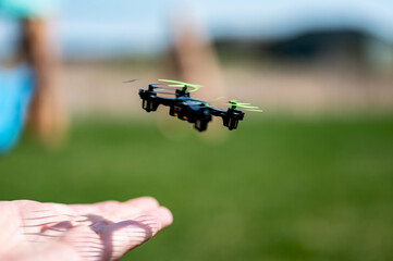 Miniature toy remote controlled drone taking off from a hand