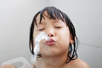 Cute Asian little girl playing in the bath

