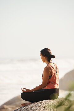 Serene woman meditating on seashore