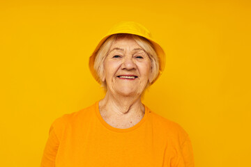 Photo of retired old lady happy lifestyle in a yellow headdress yellow background