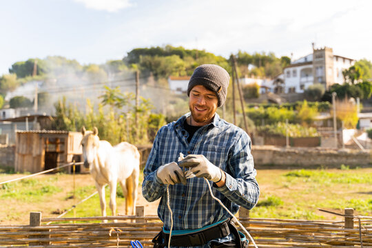 Young man connecting electric shepherd outdoor