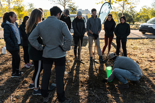 Volunteer group leader explaining how to plant a tree