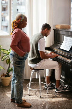 Mother listening to son playing piano