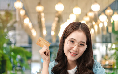 A beautiful young Asian woman has a credit card in her hand to pay for a hotel room in a hotel...
