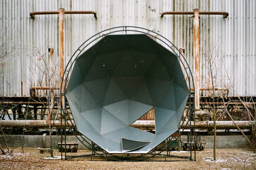 A geodesic round structure abandoned in a snowy day