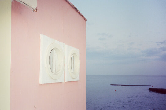 Pink building, round and square windows and the sea view
