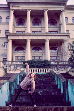 Model makes a cool pose in front of an old hotel