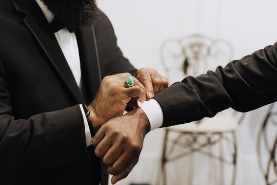 Groomsman Adjusting Cufflink on Groom