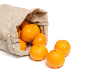 Scattered tangerines from bag on white background.