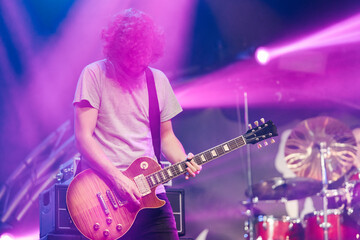 Bearded musician playing electric guitar during live concert