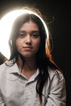 surreal photo of a teen with glowing halo disc behind