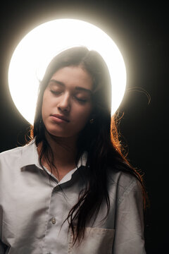 surreal portrait of a teen with glowing halo behind her