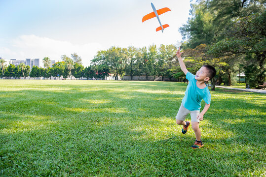 Boy playing toy plane happily.