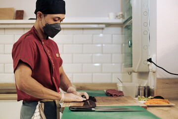 Cook preparing sushi in a restaurant