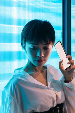 Young woman using the phone in and cold light