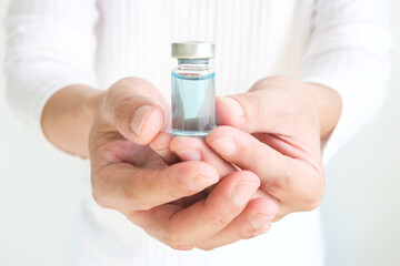 Man's hand holding a bottle of vaccine against COVID-19
Concept of medicine and vaccination