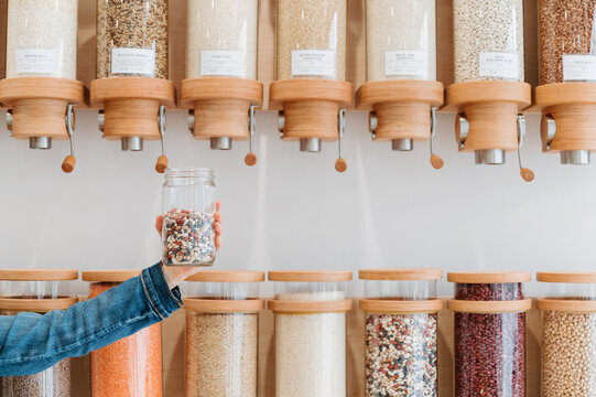 Holding a Reusable Jar of Beans in a Plastic-Free Grocery Store