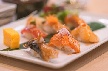 Sushi set in a white plate on the table, selected focus on Salmon sushi, close up Sushi set. Healthy Japanese food.