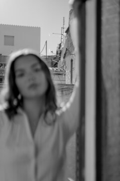 Blurry Portrait Of Woman Standing At Balcony Doors 