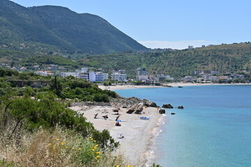 Saranda in Albania with panoramic view of the sandy beach and coastline with blue sea, mountains in the background and blue sky in summer