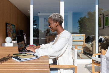 Black self employed woman browsing laptop