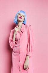 portrait of a woman in blue wig pink dress red lips pink background