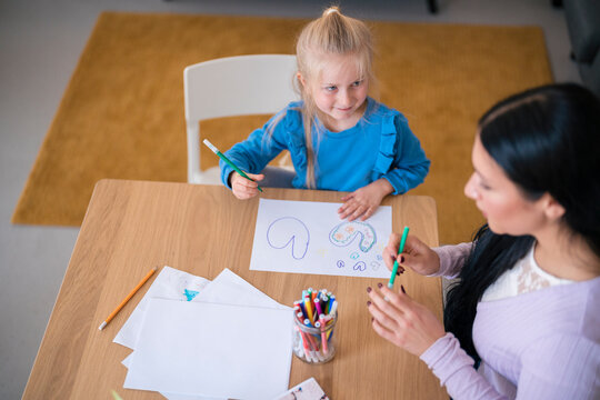 Girl and woman creating picture together