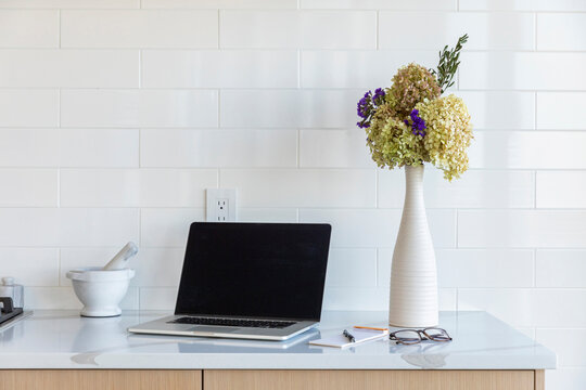 Laptop on kitchen counter in modern home 