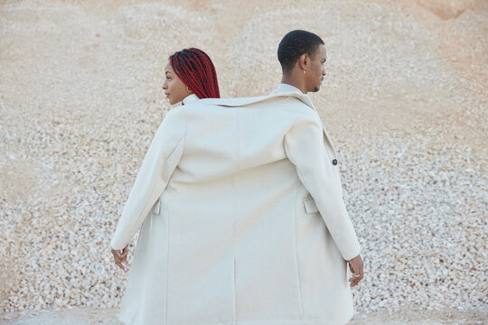 Black couple sharing a coat at desert