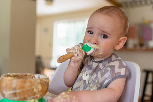Baby Makes Funny Face When Eating Food in High Chair