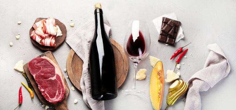 Red wine Primitivo with appetizers on gray background.