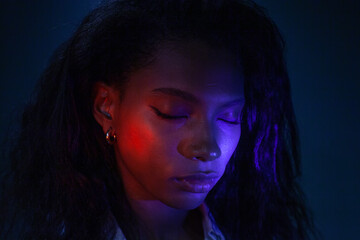 female portrait with closed eyes in neon light 