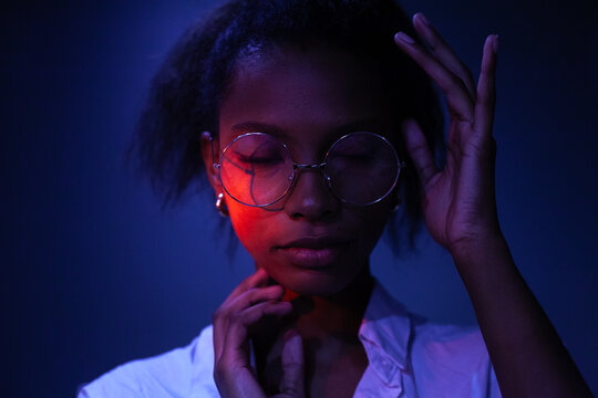 Female Studio Portrait In Neon Light, Wearing Glasses