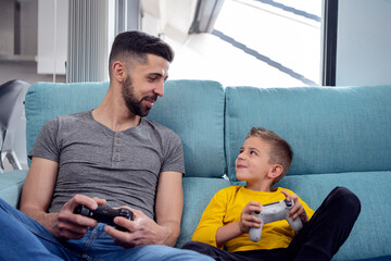 Father and son playing computer game at home