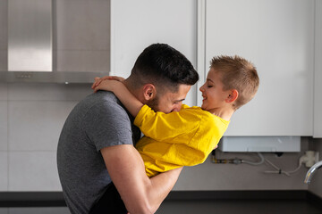 dad playing with his son while holding him in his arms