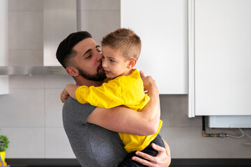 man hugging and kissing his son on the cheek