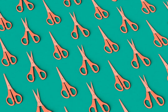 Pink open and closed scissors on a green background