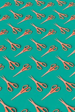 vertical pattern of Pink scissors on a green background