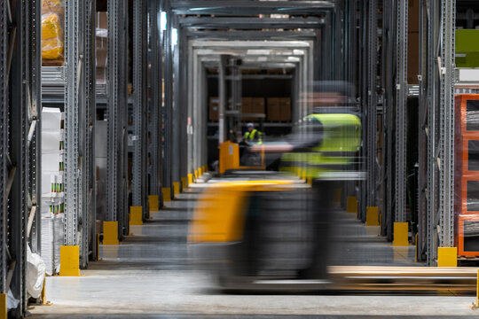 Workers on forklifts in motion 
