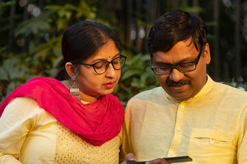 A couple viewing their photographs in a compact camera