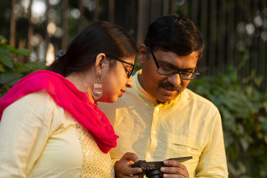 A couple viewing their photographs in a compact camera