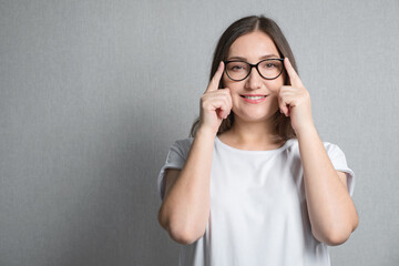 brunette woman holding glasses with two hands on the bridge of nose, copy space