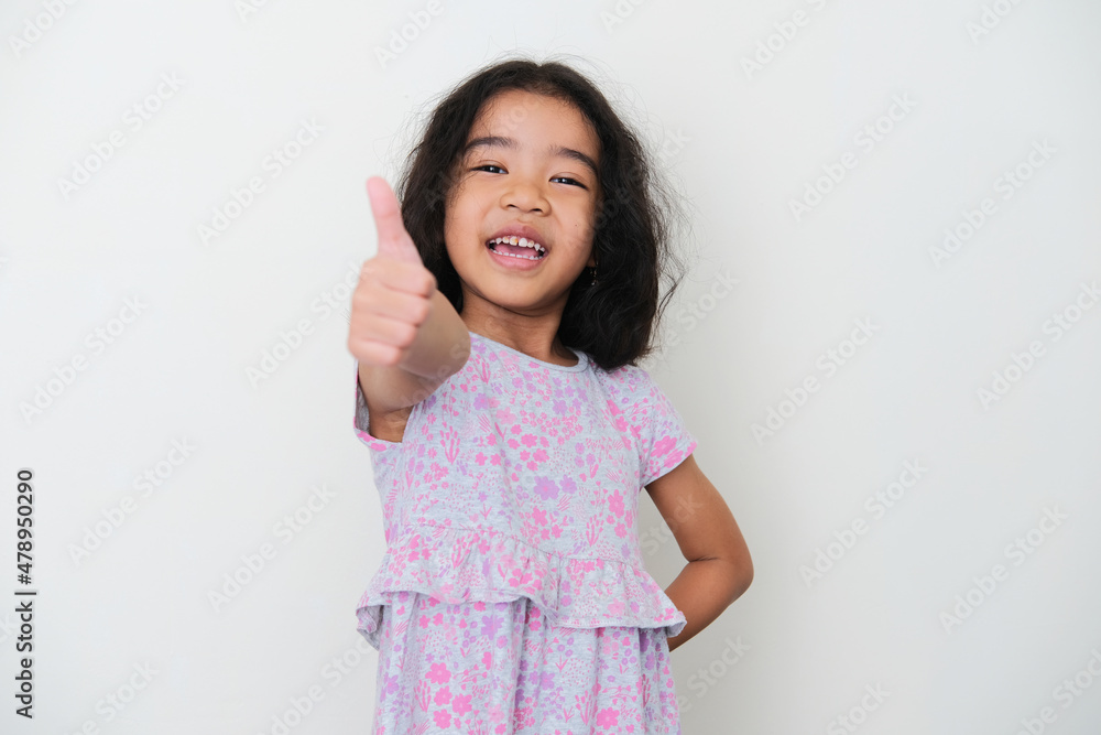 Wall mural Asian kid smiling while give thumb up