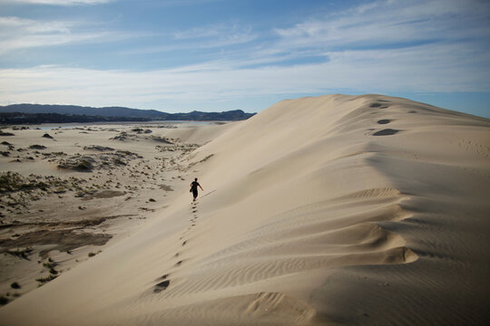 A man walking on a lonely sand dune