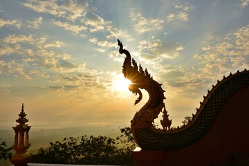 Silhouette Naga Sculpture with beautiful Sunrise sky. Wat Phra That Doi Phra Chan, Lampang...